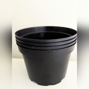 Set of eight six inch plastic plant pots.